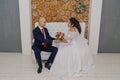 Beautiful and happy bride and groom are sitting on the couch. Royalty Free Stock Photo