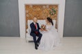 Beautiful and happy bride and groom are sitting on the couch. Royalty Free Stock Photo