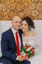 Beautiful and happy bride and groom are sitting on the couch. Royalty Free Stock Photo