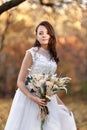 beautiful happy bride holding wedding autumn bouquet