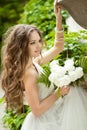 Beautiful happy bride with long wavy hair and wedding makeup ho Royalty Free Stock Photo