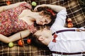 beautiful happy bride and stylish retro groom lying on tweed blanket, cuddling and relaxing, picnic in sunny meadow Royalty Free Stock Photo