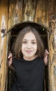 Cute happy brown eyes girl peeking out from the window Royalty Free Stock Photo