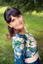 Beautiful happy brunette woman in the park on a warm summer day Royalty Free Stock Photo