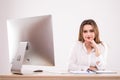 Beautiful happy businesswoman using computer while sitting at the desk at office on the white background Royalty Free Stock Photo