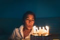 Beautiful happy caucasian asian woman blowing candles on birthday cake. Royalty Free Stock Photo