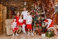 Beautiful happy Caucasoid family of five in white and red clothes for Christmas. children and parents