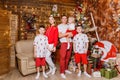 Beautiful happy Caucasoid family of five in white and red clothes for Christmas. children and parents