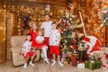 Beautiful happy Caucasoid family of five in white and red clothes for Christmas. children and parents