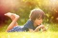 Beautiful happy child, boy, exploring nature with magnifying glass, summertime Royalty Free Stock Photo