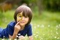 Beautiful happy child, boy, exploring nature with magnifying glass, summertime Royalty Free Stock Photo