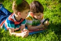 Beautiful happy children, boy brothers, exploring nature with magnifying glass, summertime Royalty Free Stock Photo
