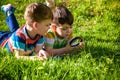 Beautiful happy children, boy brothers, exploring nature with magnifying glass, summertime Royalty Free Stock Photo