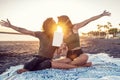 Beautiful happy couple on a date,  kissing and showing a book or an empty white card on the tropical beach Royalty Free Stock Photo