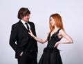 Beautiful happy couple flirting and speaking on blue background in evening fashion clothing. Redheaded hairstyle laughing girl and Royalty Free Stock Photo
