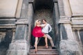 Beautiful happy couple in love embracing and dancing at old building in sunny street. stylish hipster groom and blonde bride in Royalty Free Stock Photo