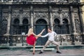 Beautiful happy couple in love embracing and dancing at old building in sunny street. stylish hipster groom and blonde bride in Royalty Free Stock Photo