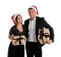 Beautiful happy couple in Santa hats holding Christmas gifts on white background Royalty Free Stock Photo