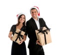 Beautiful happy couple in Santa hats holding Christmas gifts on white background Royalty Free Stock Photo