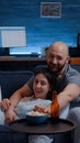 Beautiful happy couple watching TV on couch relaxing at night laughing Royalty Free Stock Photo