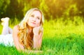 Beautiful happy dreamy woman in summer on nature lying on grass