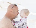 Beautiful Happy Expressive Blond Girl Toddler on the Beach with her Grandfather Royalty Free Stock Photo