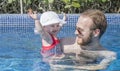 Beautiful Happy Expressive Blond Girl Toddler in the Pool with her Father