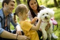 Beautiful happy family is having fun with bishon dog outdoors Royalty Free Stock Photo