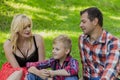 Beautiful happy family resting on a picnic on a sunny day. Royalty Free Stock Photo