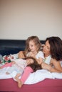 Beautiful happy family scene with mother talking to her little daughter with her doll