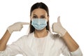 Beautiful happy female doctor or nurse wearing protective mask and latex or rubber gloves on white background with thumbs up Royalty Free Stock Photo
