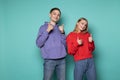 Beautiful happy friends boy and girl in casual clothes showing thumbs up and looking at the camera Royalty Free Stock Photo