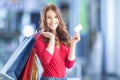 Beautiful happy girl with credit card and shopping bags in shopping mall. Shopping Center in the background. Royalty Free Stock Photo