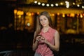 Beautiful happy girl in the evening in the park stands with burning lanterns. Royalty Free Stock Photo