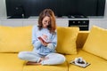 Likable young woman writing her personal notes into her diary while sitting in the modern stylish kitchen.