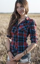 Beautiful happy girl in the field, sunny afternoon, shorts shirt. The concept of enjoying nature. Rest on the air Royalty Free Stock Photo