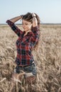 Girl in a field shirt shorts, wheat outdoor recreation, beautiful hair. Corrects hair. Royalty Free Stock Photo