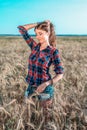 Girl in a field shirt shorts, wheat outdoor recreation, beautiful hair. A student walks after school. The woman`s long Royalty Free Stock Photo