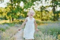 beautiful happy girl running in meadow. Beautiful warm summer evening. Little child in lavender field. Freedom, childhood, Royalty Free Stock Photo