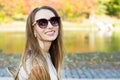 Beautiful happy girl in sunglasses smiling on a park background Close Up, portrait of beautiful stylish smile woman closeup Royalty Free Stock Photo