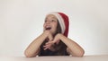 Beautiful happy girl teenager in a Santa Claus hat look and emotionally expresses a surprise on white background Royalty Free Stock Photo