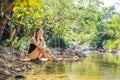 Beautiful happy girl, young pretty cheerful woman traveler sitting, swinging on a swing tied to a tree above the water Royalty Free Stock Photo