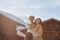 beautiful happy girls hugging while standing between wooden houses in mountain village mont