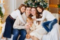 Beautiful happy large family on the couch by the Christmas tree. Royalty Free Stock Photo