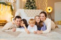 Beautiful happy large family on the floor in room with the Christmas tree. Royalty Free Stock Photo