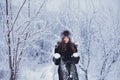 Beautiful happy laughing young woman wearing winter hat gloves covered with snow flakes. Royalty Free Stock Photo