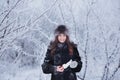 Beautiful happy laughing young woman wearing winter hat gloves covered with snow flakes. Royalty Free Stock Photo