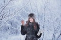 Beautiful happy laughing young woman wearing winter hat gloves covered with snow flakes. Royalty Free Stock Photo