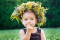 Beautiful happy little baby girl in a wreath on a meadow on the nature Royalty Free Stock Photo