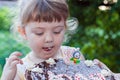 Beautiful happy little girl biting birthday cake Royalty Free Stock Photo